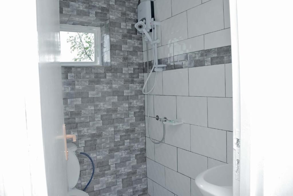 A bathroom with a shower, toilet, and sink.