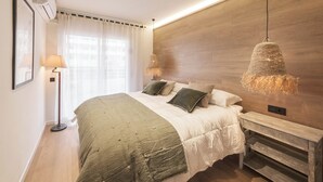 Un dormitorio con cama, mesitas de noche, lámpara y una lámpara colgante.