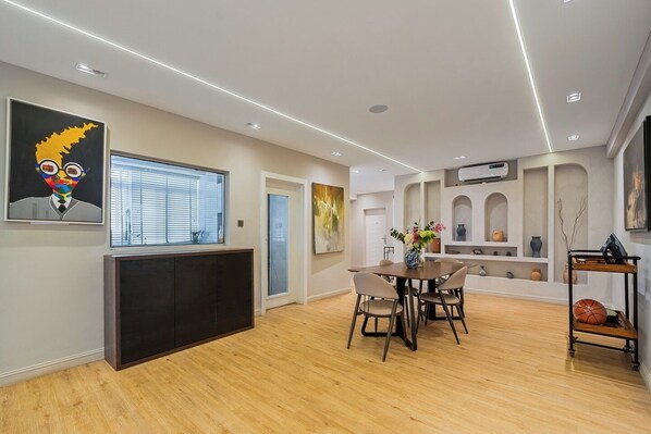 Una sala de estar moderna con comedor, un ventanal grande y chimenea.