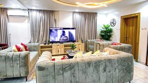 Un soggiorno moderno con divano, televisione e lampada decorativa a soffitto.