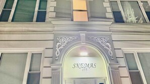 A building with a classic architectural style, featuring a prominent entrance with a decorative arch and the name 'SKEMAAS' above the door.