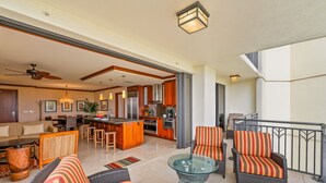 Un'ampia zona giorno con tavolo da pranzo, cucina e balcone con posti a sedere esterni.