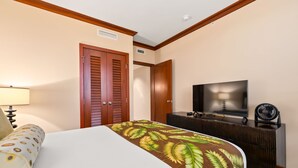 Una camera d'albergo con un letto, una televisione, una cassettiera e una porta.