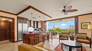 Una cucina moderna con angolo bar, zona pranzo con sedie, un tavolo rotondo e un balcone con vista.