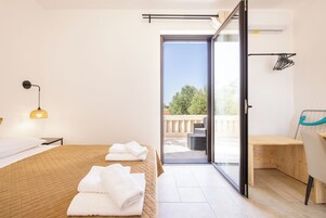 Una camera d'albergo moderna con un letto, una scrivania e un balcone.