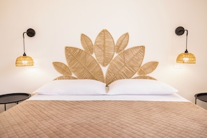 A bed with a textured headboard, two bedside lamps, and a quilted bedspread. - Masseria Coccolo (Carovigno)