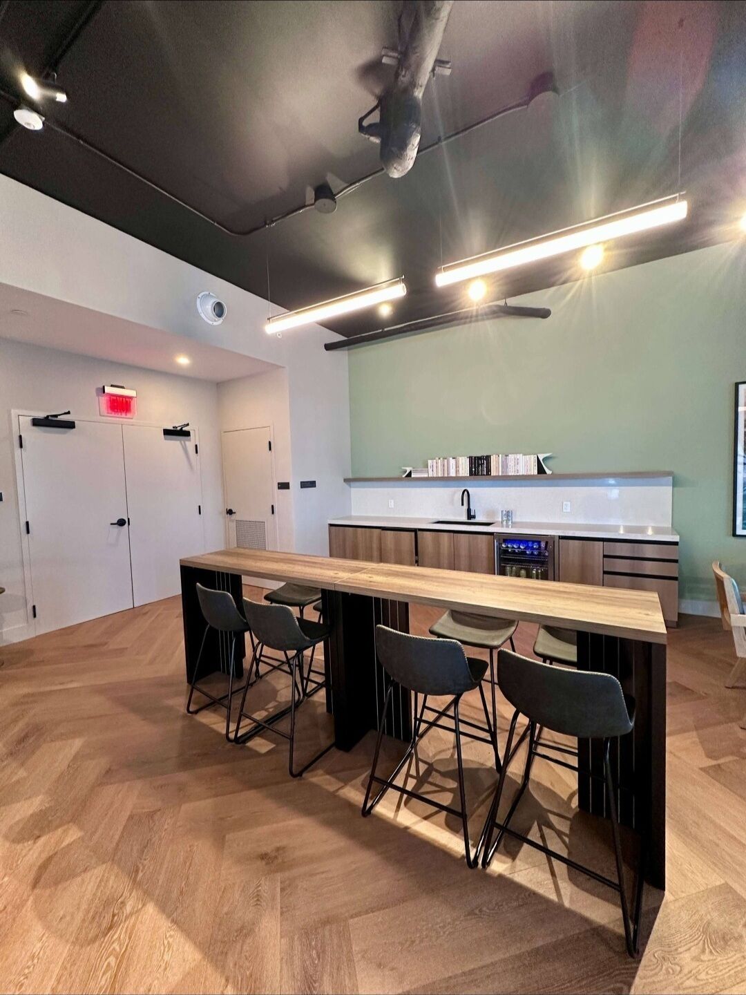 A modern kitchen with a central island, bar stools, and a dining table.