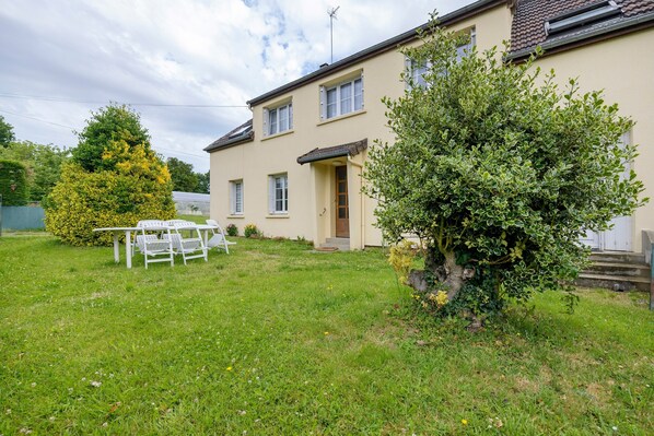 A house with a front yard, a small table, and chairs. - Gîte Chez Madeleine: Private Terrace, Garden, and Wi-Fi in Coutances (Coutances)