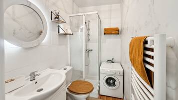 Een douche, handdoeken, zeep, toiletpapier