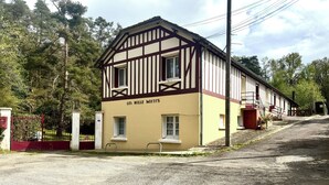 Un edificio tradizionale a graticcio con un cartello che riporta 'LES MILLE MOTTS'.