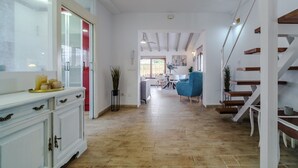 A spacious hallway with a wooden floor, a staircase, and a dining area in the background. - Holiday Home 'Jávea - Just Steps from the Sea' with Private Terrace, Wi-Fi & AC (Jávea)