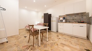 A compact kitchen with a dining area, a refrigerator, and a microwave. - Holiday House Annunziata 1 Apartment with Wi-Fi and Air Conditioning (Termini Imerese)
