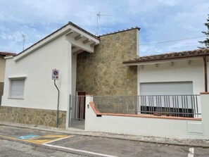 A building with a stone facade, a garage door, and a metal railing. - Bright renovated apartment - Quiet area Florence Poggio Imperiale Center (Firenze)