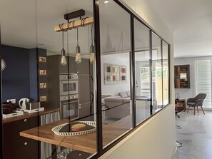 Eine moderne Küche mit eingebauten Geräten, einem Holzespeisetisch und einer Glastrennwand.