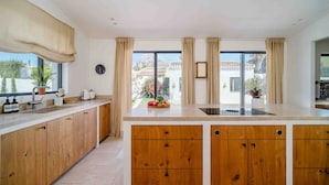 Una cocina moderna con armarios de madera, una isla grande y vistas al exterior.