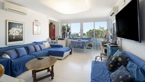 A living room with a sofa, a table, a TV, and a view of the outdoors. - Villa with Pool 800 Meters from Playa de Pals (Pals)