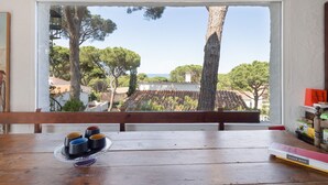 A wooden table with a view through a window, a tray with cups, and a book on the right. - Villa with Pool 800 Meters from Playa de Pals (Pals)