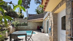 A patio with a pool, stone walls, and a table with chairs. - Ground Floor Apartment with Private Pool (Sa Riera)