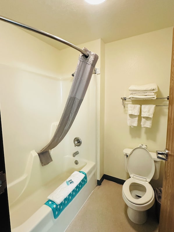 A bathroom with a bathtub, a toilet, and a towel rack. - Imperial Inn (Imperial)