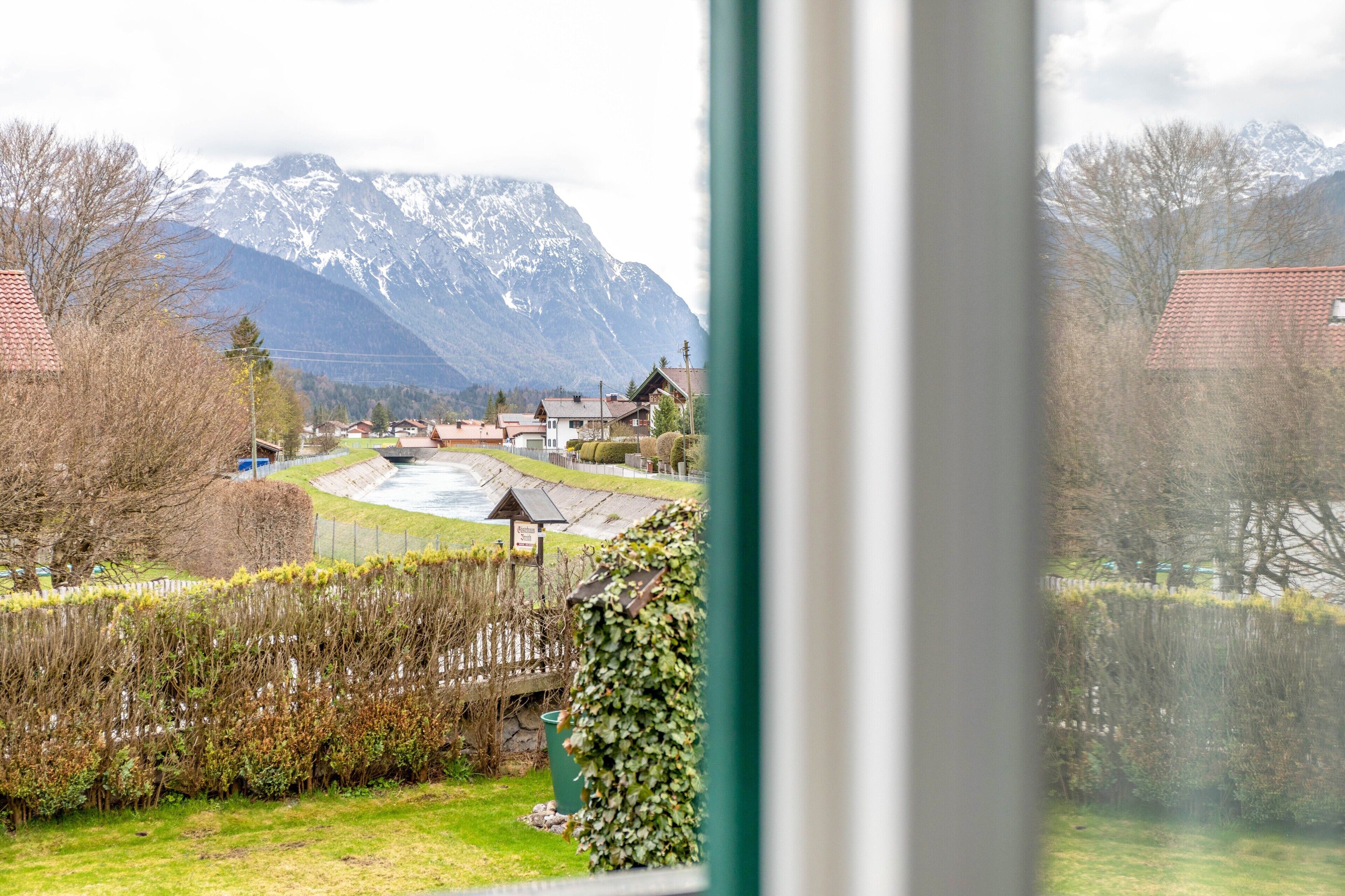 Ein Wohngebiet mit Häusern, einem Fluss und Bergen im Hintergrund.