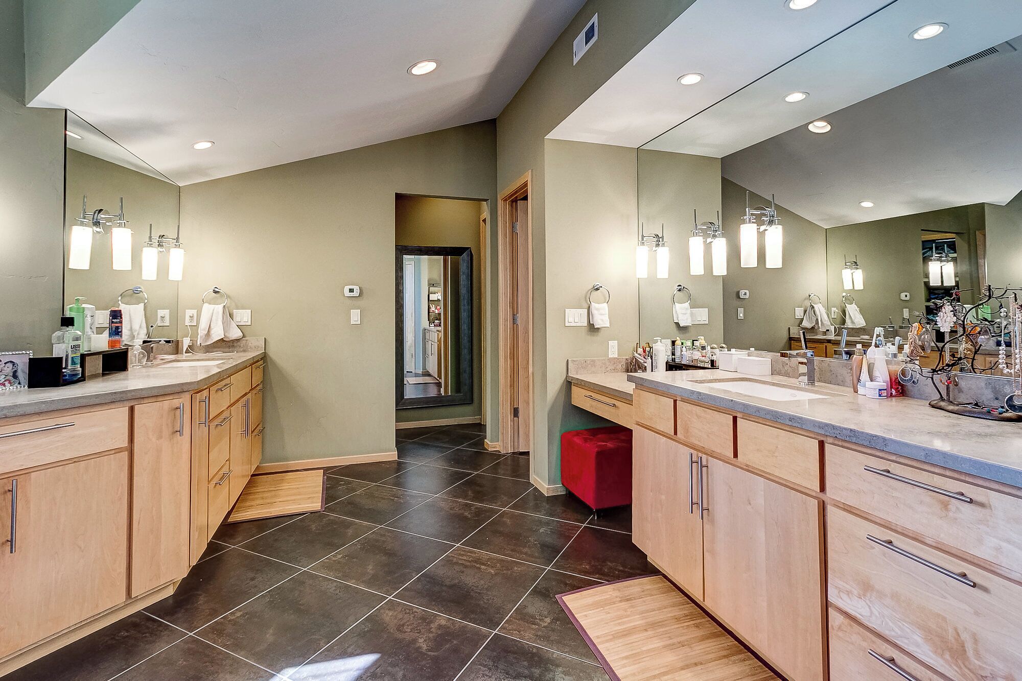 A modern bathroom with two sinks, wooden cabinets, and a large mirror.