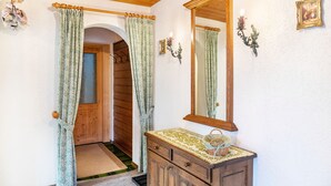 A room with a wooden door, a mirror, a dresser, and a small rug. - Apartment 'Parterre' with Mountain View, Private Terrace and Wi-Fi (Wallgau)