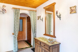 A room with a wooden door, a mirror, a dresser, and a small rug. - Apartment 'Parterre' with Mountain View, Private Terrace and Wi-Fi (Wallgau)