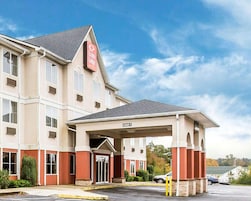 A hotel with a covered entrance, multiple windows, and a sign indicating 'Econo Lodge.'