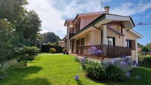 A two-story house with a balcony, surrounded by a well-maintained lawn and garden. - Holiday Home 'La Marina' with Sea View, Private Terrace and Wi-Fi (Barro)
