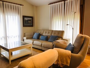 A living room with a sofa, armchair, coffee table, and a floor lamp.