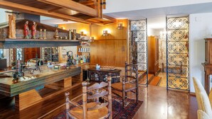 Decoração em madeira com área de bar, cadeiras e um painel decorativo.