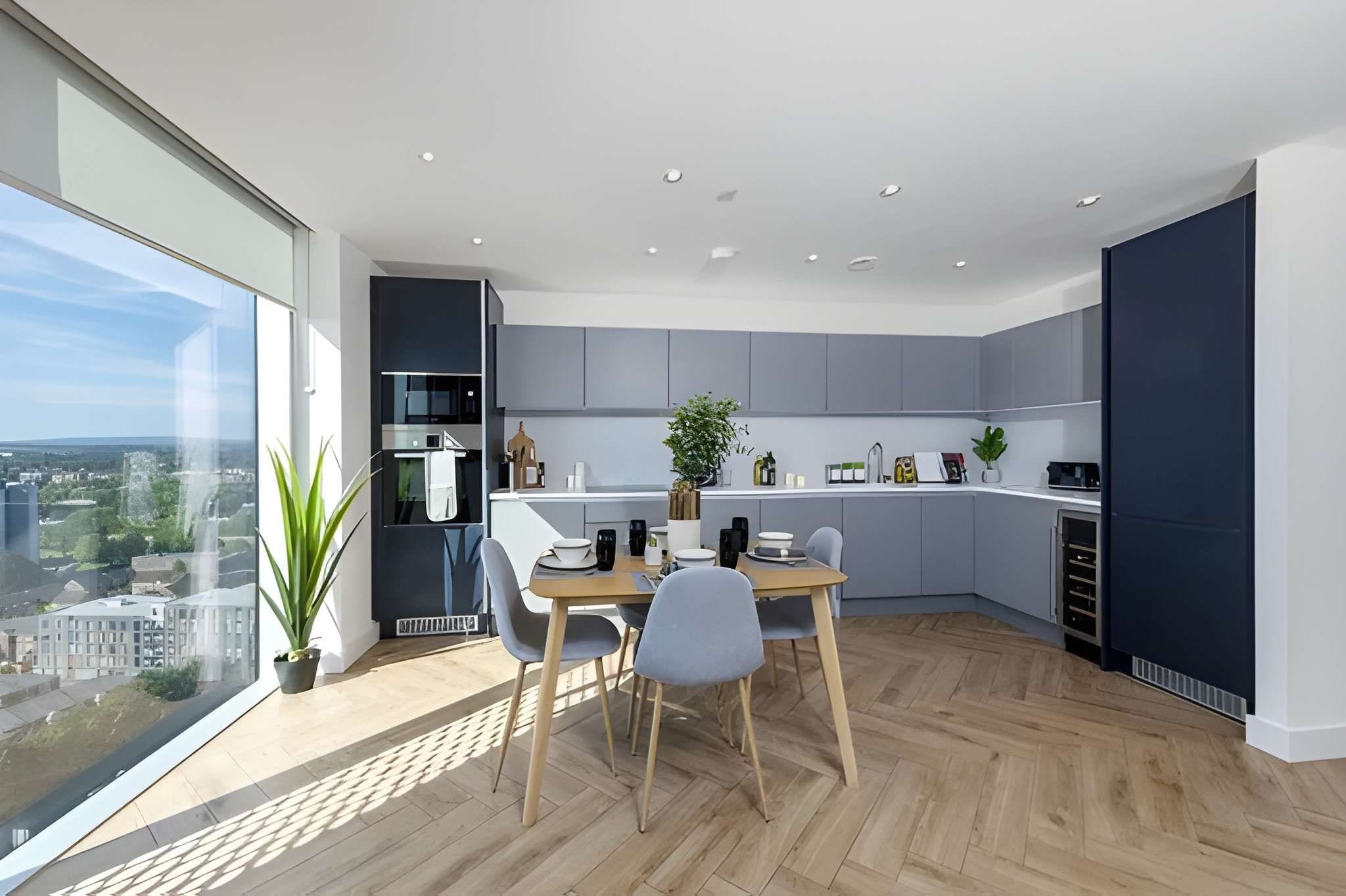 Une cuisine moderne avec un coin repas, de grandes fenêtres et une vue sur la ville.
