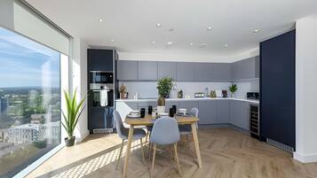 Une cuisine moderne avec un coin repas, de grandes fenêtres et une vue sur la ville.