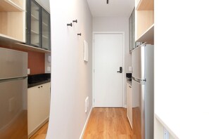 Une petite cuisine équipée d’un réfrigérateur, d’une cuisinière et de placards.