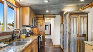 A kitchen with wooden cabinets, a stainless steel sink, and a wooden countertop. - Zebra Ranch 150 Guest Venue Lodging Mtn Vu Farm (Prescott)