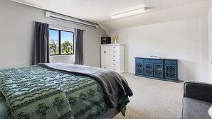 A bedroom with a bed, a dresser, a window with curtains, and an air conditioning unit. - Zebra Ranch 150 Guest Venue Lodging Mtn Vu Farm (Prescott)
