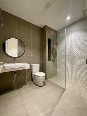 A bathroom with a sink, toilet, and glass-enclosed shower. - Quill Residences By Happy Stay (Kuala Lumpur)