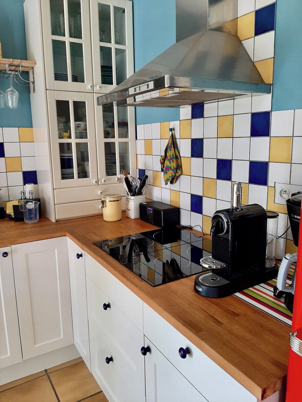 A kitchen with white cabinets, a black coffee machine, and a window with a view.