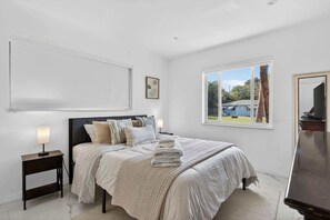 A bedroom with a bed, bedside tables, a window, and a view of the outside. - Tropical Oasis w/ Private Pool (Fort Lauderdale)