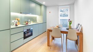 Una cucina moderna con zona pranzo, pavimento in legno e vista sulla città.