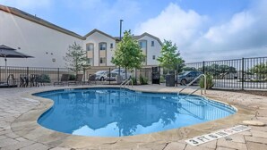 A swimming pool with a 3ft 6in depth marker, surrounded by a paved patio with outdoor furniture. - 1bhk Furnished Retreat Cedar Park Austin Stay (Cedar Park)
