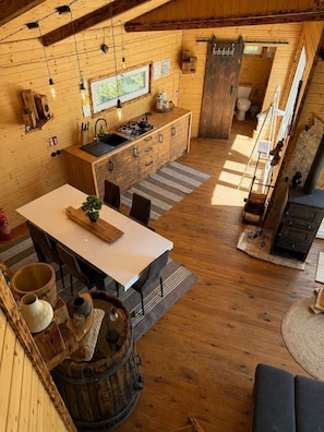 Un interior rústico de madera con cocina, comedor y chimenea.