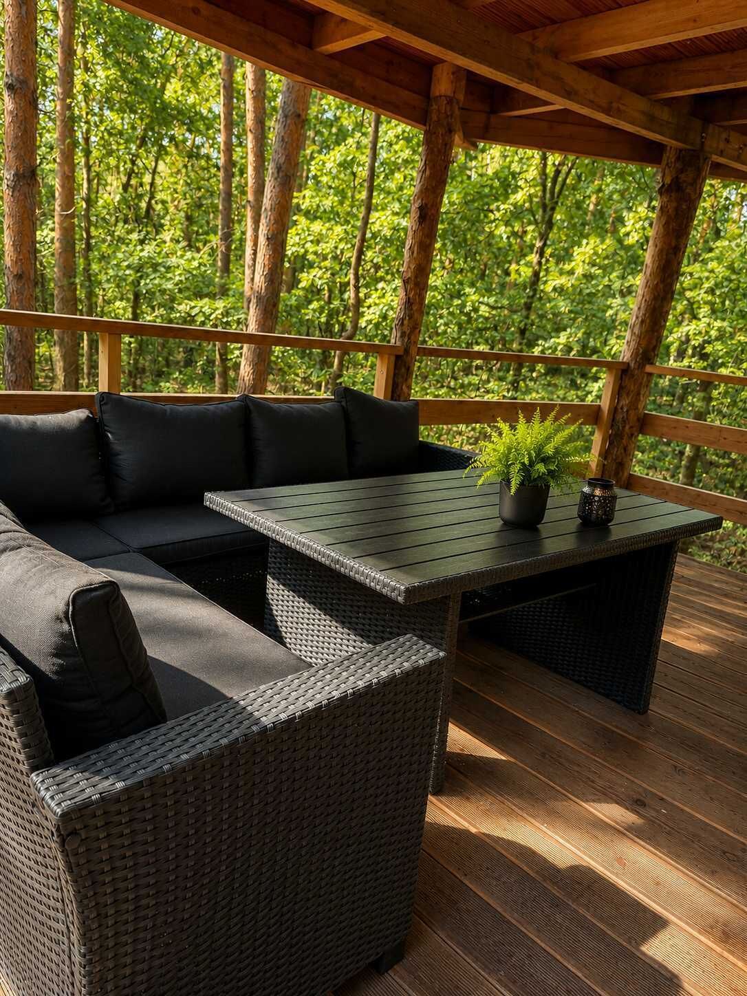 Un espace extérieur aménagé, abrité et doté d’un canapé, d’une table et de chaises.