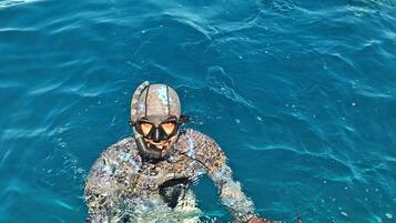 Una persona en una piscina sosteniendo un pez.