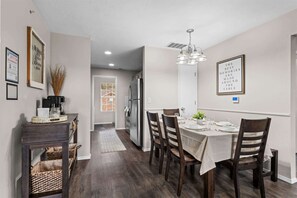 A dining area with a table set for four, a refrigerator, and a coffee machine. - Have it All! Pool Access (Branson)