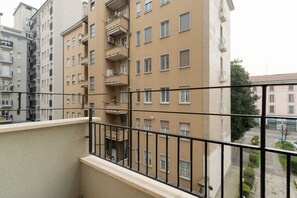 Ein mehrstöckiges Wohngebäude mit Balkonen, einem sichtbaren Fenster und Blick auf die Straße.