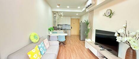 A modern living room with a sofa, TV, and decorative plants.