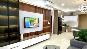 Een moderne woonkamer met een flatscreen televisie, een plafondventilator en een bank.