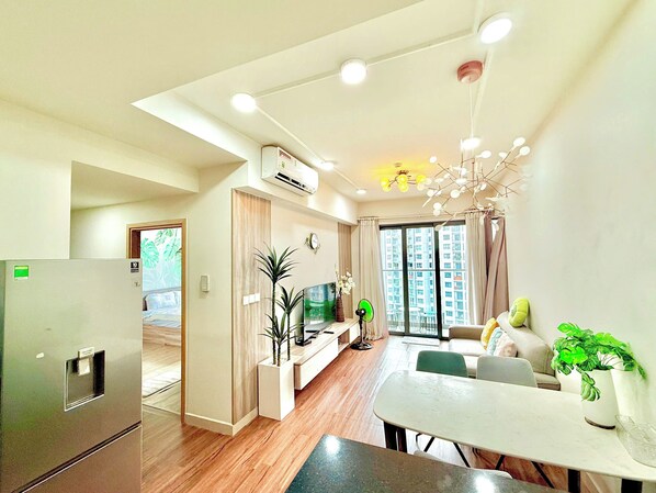 Una sala de estar moderna con comedor, cocina y un amplio ventanal con vista a la ciudad.