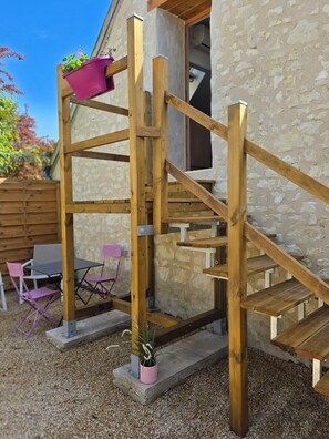 A wooden outdoor staircase leading to a building with a stone facade. - GITE L'Essentiel Piscine clim between Beauval Futuroscope and Châteaux de la Loire (Sainte-Maure-de-Touraine)